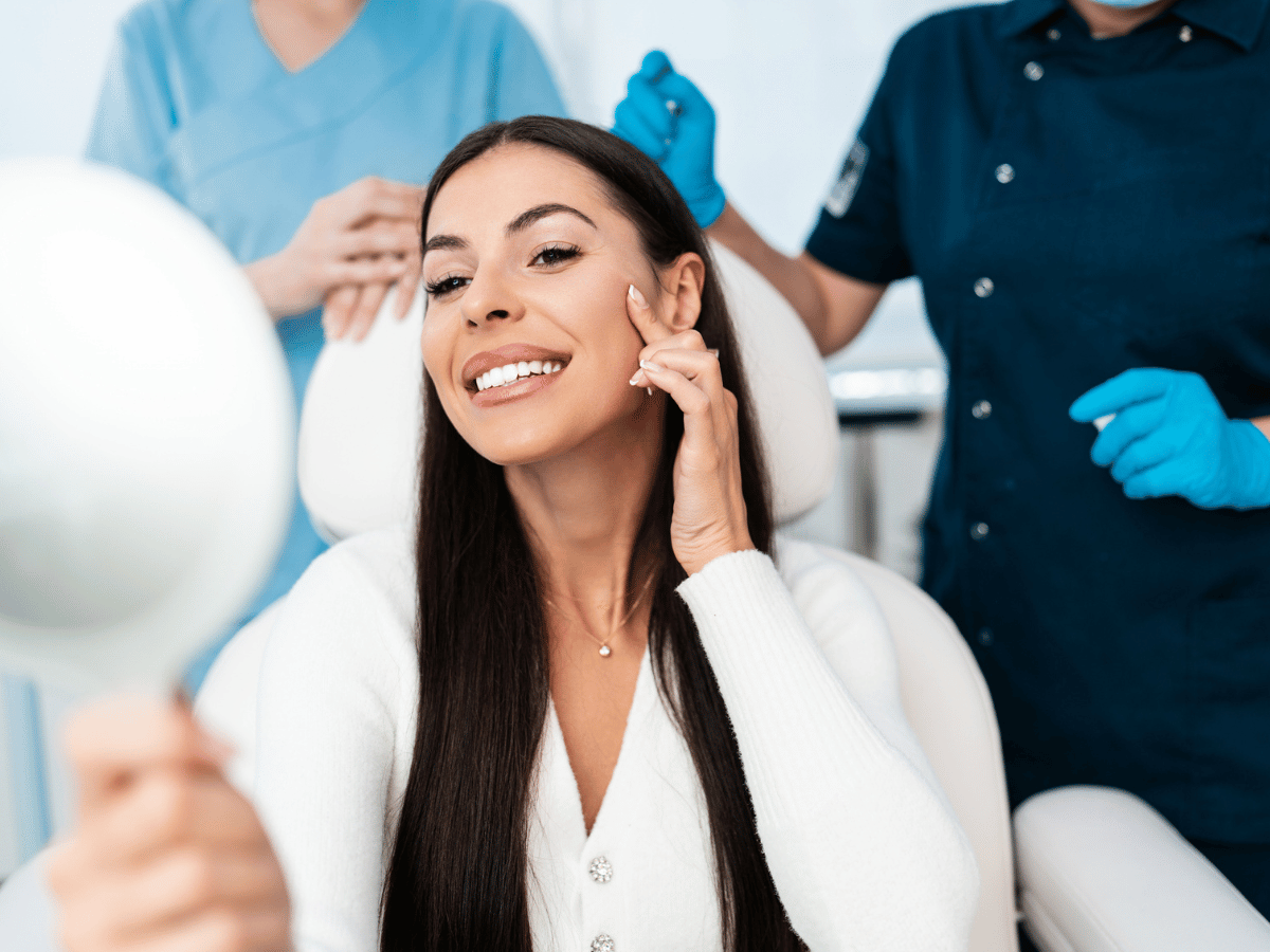 woman smiling in chair in exam room with doctors