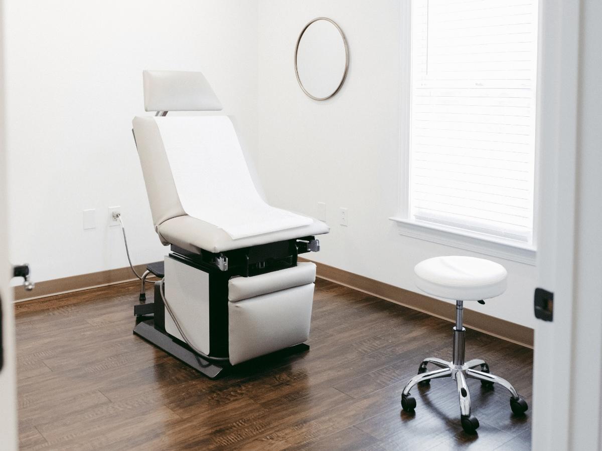 Image of clean and sanitized exam room with chair, stool, and mirror