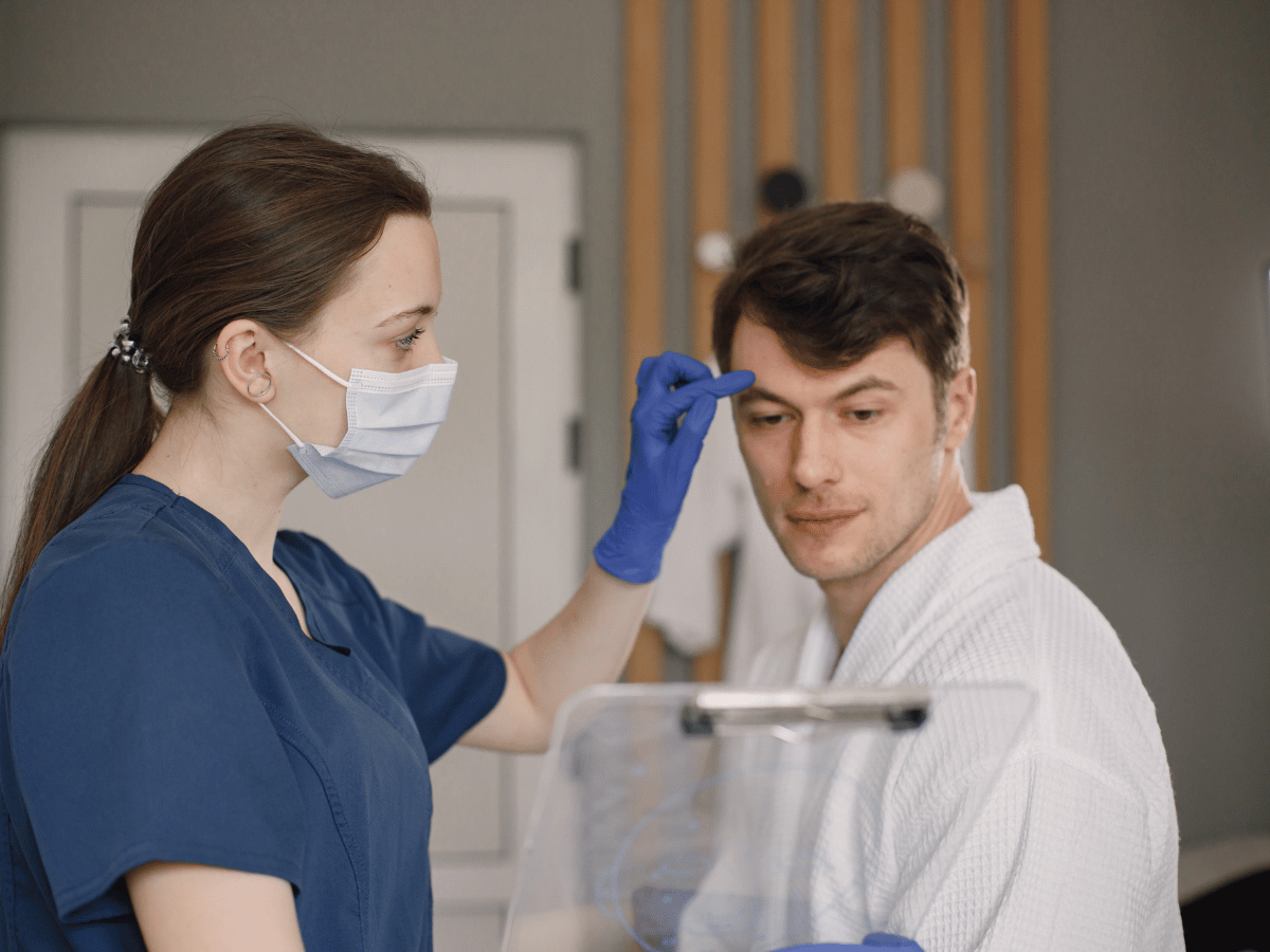 female doctor treating male patient in exam room